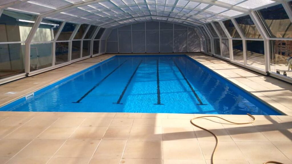 Indoor swimming pool with retractable enclosure and tiled flooring